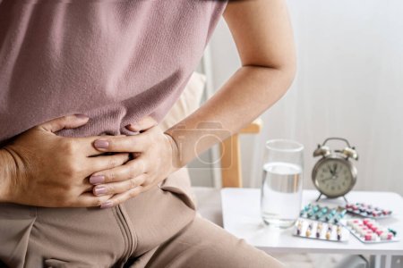 Photo for Irritable bowel syndrome IBS concept with woman hand holding a stomachache having problems with the digestive system like diarrhea and constipation - Royalty Free Image