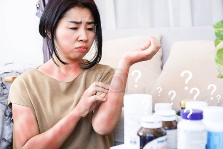Téléchargez les photos : Femmes asiatiques gratter sur les démangeaisons, éruption cutanée causée par des réactions allergiques aux suppléments et les effets secondaires de la prise excessive de multivitamines - en image libre de droit
