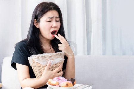 Foto de Bulimia nerviosa, concepto de anorexia nerviosa con mujer asiática poner los dedos en la boca y sosteniendo la bandeja en la mano tratar de vomitar después de comer alimentos - Imagen libre de derechos