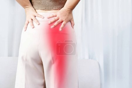Foto de Concepto de dolor de ciática con la mujer que sufre de dolor de nalga que se extiende a la pierna hacia abajo - Imagen libre de derechos