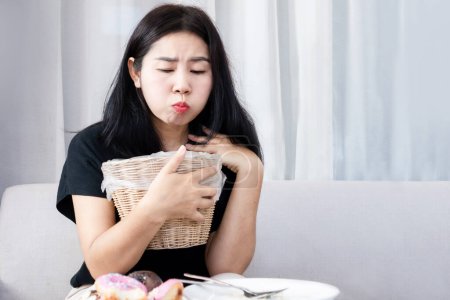 Foto de Mujer asiática sosteniendo bin en la mano intenta vomitar y dieta después de comer alimentos, Bulimia nerviosa, concepto de anorexia nerviosa - Imagen libre de derechos
