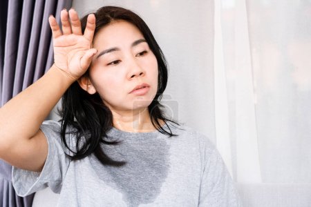 sweating Asian woman in summer with hot weather wearing sweat shirt