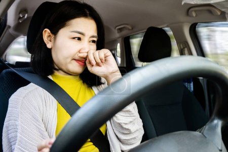 Téléchargez les photos : Gros plan de femme asiatique insatisfaite voiture de conduite, frustré par véhicule malodorant - en image libre de droit