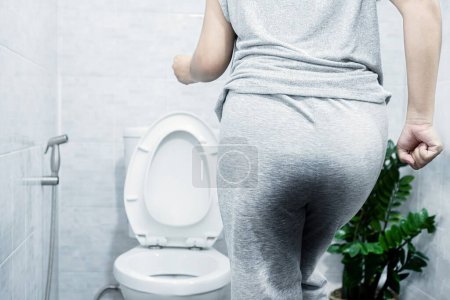 Frauen haben Probleme mit Stress Harninkontinenz, Blasenkontrolle und überaktiver Blase (OAB), die es nicht schafft, mit nassen Hosen pünktlich auf die Toilette zu gehen