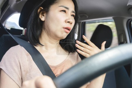 Foto de Mujer asiática conductor tiene un problema con un acondicionador que no funciona, sensación de calor y sudoración de las olas de calor en un coche mientras conduce en verano clima caliente - Imagen libre de derechos