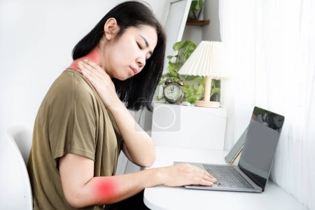 Foto de Concepto de Radiculopatía Cervical (Nervio Pellizcado) con una mujer asiática que sufre de dolor de cuello y hombro que irradia en el brazo por el uso de computadoras a largo plazo - Imagen libre de derechos