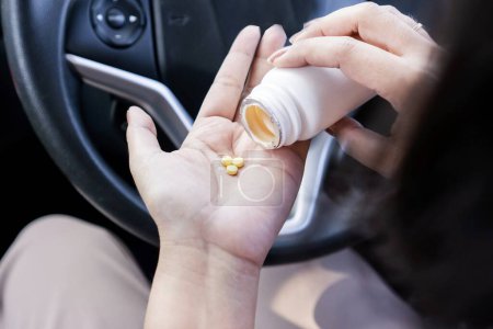 Photo for Closeup woman hand taking Antihistamines or allergy medicine before driving could affect Sleepiness and Risk of Accidents - Royalty Free Image