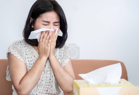 Photo for Asian woman sneezing because of cold and flu, dust allergy - Royalty Free Image