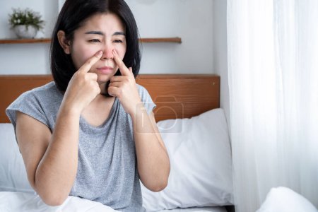 Femme asiatique souffrant d'une infection sinusale ayant le nez qui coule et le nez bouché