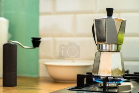Foto de Esta foto de stock captura la esencia de la cafetera tradicional con una Mokka Pot en una estufa de gas en una cocina casera. El diseño clásico de la Mokka Pot y la llama azul de la estufa de gas añaden un toque de encanto vintage a la imagen, por lo que es perfecto - Imagen libre de derechos