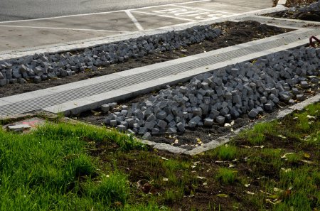 Photo for Pavers made of stone cubes who can create beautiful mosaics. piles prepared in fine gravel for laying between curbs. the mayor ordered new sidewalks from the construction company - Royalty Free Image