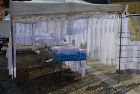 Photo for Marketplace with transparent lace curtains in a stall on the square. a tent on which the exposed window decorative fabrics hang from the structure. lacemaking - Royalty Free Image