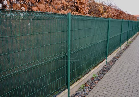Téléchargez les photos : Le tissu d'ombrage sur la clôture métallique crée un espace privé et en un instant, vous avez une clôture opaque de voisins ennuyeux et des vues de la rue, chantier de construction, haie de corne d'asphalte - en image libre de droit