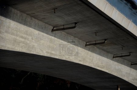 Téléchargez les photos : Drainage du pont routier. construction en arc de pont avec drainage, tuyaux en acier inoxydable fixés avec des supports sur la face inférieure. l'eau va dans les égouts pluviaux - en image libre de droit