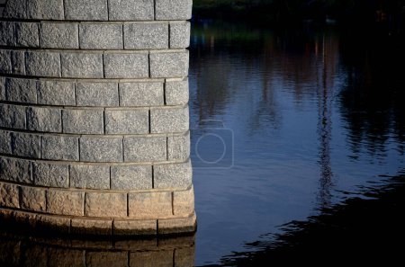 Téléchargez les photos : La combinaison d'un mur de pierre de taille lisse en bandes longitudinales suit l'arc de blocs de granit rugueux. pilier, clôture de la construction de brouillards et murs de soutènement de pierre. tailleur de pierre local - en image libre de droit