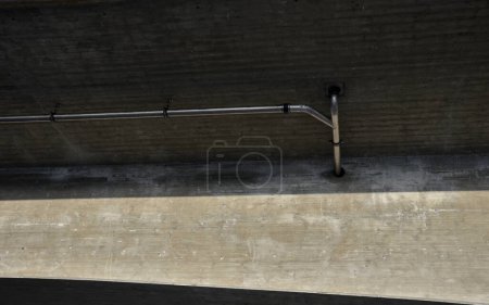 Téléchargez les photos : Drainage du pont routier. construction en arc de pont avec drainage, tuyaux en acier inoxydable fixés avec des supports sur la face inférieure. l'eau va dans les égouts pluviaux - en image libre de droit