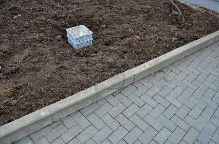 roof gutter covered with a square plastic green grid. green roofs covered with substrate. the area around the drain is mulched with stone mulch from pebbles, geolextile, renovation, dirt, soil, land
