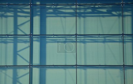 Téléchargez les photos : Derrière la façade en verre sur les tuyaux métalliques, vous pouvez voir des rideaux, des stores comme protection contre le soleil fort. les bâtiments modernes sont parfois occupés comme serres. régulation, chauffage par rayonnement solaire - en image libre de droit