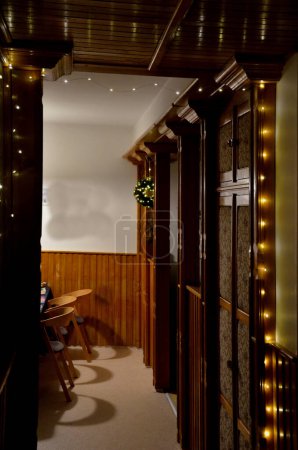 Téléchargez les photos : Ambiance du soir d'une maison de Noël décorée. Éclairage LED avec câbles lumineux autour des panneaux de bois d'orme. colonnes antiques créent une ambiance festive juste à l'entrée. photos, dessins, mur - en image libre de droit