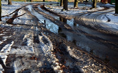Téléchargez les photos : Point tournant des camions d'entretien dans le parc de la ville. neige mouillée avec de l'eau et de la boue menaçant le débardage du véhicule - en image libre de droit