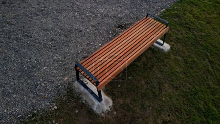 Téléchargez les photos : Reddish wood benches on their paneling under the benches is a rectangle of concrete anti-scraping beige paths by the shoes of visitors flowering romantic flower beds and lawn, high angle view, above - en image libre de droit