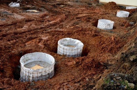 Photo for Foundation of buildings using drilled piles for private houses as well as for industrial buildings. the well was drilled either without casing or under a protective steel grating, geotextile - Royalty Free Image