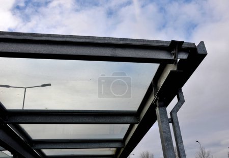strut, suspended glass roof above the building entrance. bus station, railway station. cable wind braces. aluminum construction with windows above pergola  galvanized steel frame
