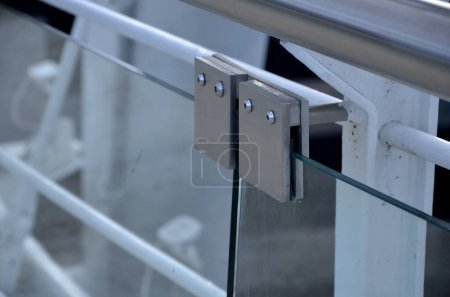 barandilla de una casa de lujo que consta de paneles de vidrio sujetos con paneles de acero inoxidable de metal gris. la barrera de vidrio esmerilado lechoso da una impresión aireada. cubierta de metal pulido