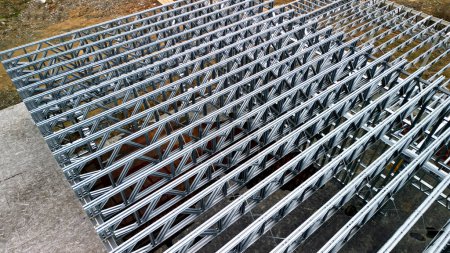 Foto de Building construction from metal trusses. lattice structure of the frame of an industrial building. A large thick tangle on the ceiling of a building under construction. shiny metal profiles steel - Imagen libre de derechos