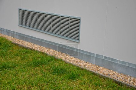 Photo for Ventilation grille along the house. basement windows are below ground level. Metal walking grid. foundation ventilation and drainage for removing moisture from masonry and bricks. pebbles, pebble, - Royalty Free Image