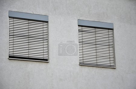 stores sur le mur du bâtiment en verre couvre la fenêtre et l'ombre du soleil l'intérieur du bâtiment. bandes de couleur or gris. métalliques connectés par des bandes de câbles commandés automatiquement