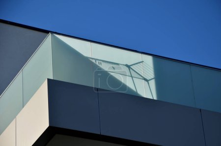 garde-corps d'une maison de luxe composée de panneaux de verre fixés avec des panneaux en acier inoxydable gris métallique. la barrière de verre laiteux givré donne une impression aérée. couverture en métal poli, ombre de corde