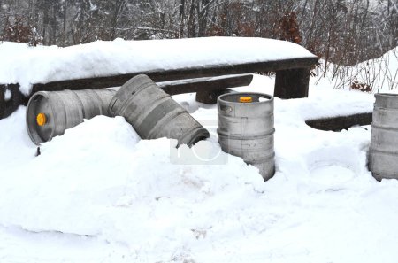 Téléchargez les photos : Bonhommes de neige à une table faite de tonneaux de bière en étain. Ça ressemble à une belle fête dans les montagnes ici. tonneaux jetés à la table du camp dans une dérive de neige. transport de fournitures à la cabane de montagne. van avec - en image libre de droit