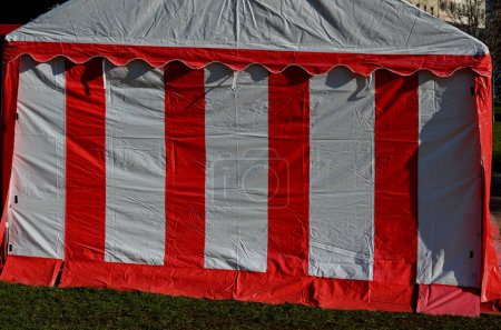 Photo for Sheets made of non-flammable materialPVC tarpaulin for trucks rear entrance equipped with zip windows made of transparent plastic Steel frame of the tent made of galvanized pipes, red, white stripes - Royalty Free Image