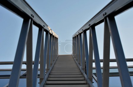 Photo for Aluminum footbridge for washing windows above the skylight. simplifying the washing of large greenhouses and galleries with ceiling windows. the ladder can be moved over the rails, blue sky, trowel - Royalty Free Image