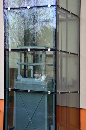 Téléchargez les photos : Un ascenseur extérieur avec une structure en verre peut être ajouté à une maison historique où il n'est pas possible d'effectuer des travaux de démolition. vous pouvez voir la cabine monter l'arbre transparent - en image libre de droit