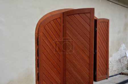 Photo for Wooden shutters for arch-shaped balcony windows. the Italian style of the baroque castle and the courtyard paved with granite pavement. hidden for garbage cans in front of the house. does not spoil - Royalty Free Image
