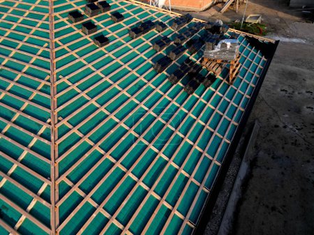 Photo for Construction site with several roofs in progress. Roofs with vapor-permeable foil. roof tiles are placed on the roof. concrete chimney passes through. approval quality control. view from above - Royalty Free Image