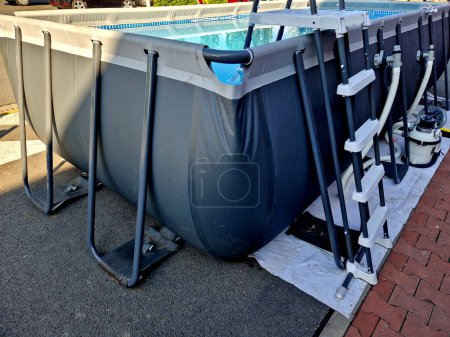 Photo for Family swimming pool with filtration and metal structure made of pipes. Quick and easy construction. An affordable solution for poorer families. cottages and terraces. chlorinated water, sandblasted - Royalty Free Image