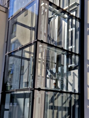 Téléchargez les photos : Un ascenseur extérieur avec une structure en verre peut être ajouté à une maison historique où il n'est pas possible d'effectuer des travaux de démolition. vous pouvez voir la cabine monter l'arbre transparent, extérieur - en image libre de droit
