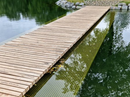 Téléchargez les photos : Poteau de parc sans balustrades. à côté de lui dans l'eau est un filet de sécurité immergé sous la surface. élargissant ainsi le pont et réduisant la possibilité de chute en profondeur - en image libre de droit