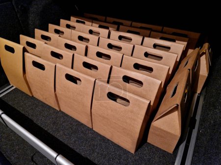 Photo for Business manager's car storage space. car trunk full of gifts from clients and business partners. employees delivering carton boxes with wine and snacks. - Royalty Free Image