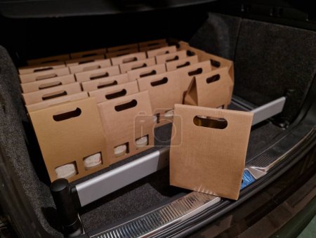 Photo for Business manager's car storage space. car trunk full of gifts from clients and business partners. employees delivering carton boxes with wine and snacks. - Royalty Free Image