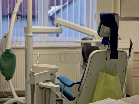 Téléchargez les photos : Examen dentaire. un homme s'assoit dans un berceau et regarde ses pieds. traitement dentaire désagréable par un dentiste. belle chaise dentaire dentistes manquants, location d'un lieu de travail cher avec les patients clients - en image libre de droit