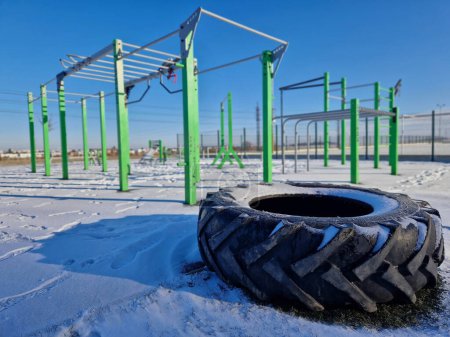 Photo for Fitness sports fields with stainless steel tools resemble torture tools with chains and handles. soft rubber surface sports ground outdoor gym. man holds a pulley and strengthens muscles - Royalty Free Image
