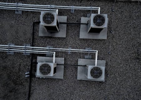Téléchargez les photos : Les unités de refroidissement sont industrielles ou climatisées, qui sont utilisées en été pour refroidir les locaux, avec des ventilateurs sur le toit de la salle de stockage, principalement pour les opérations industrielles, à angle élevé - en image libre de droit