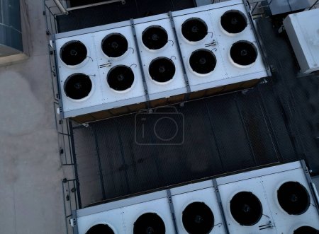 Téléchargez les photos : Les unités de refroidissement sont industrielles ou climatisées, qui sont utilisées en été pour refroidir les locaux, avec des ventilateurs sur le toit de la salle de stockage, principalement pour les opérations industrielles, à angle élevé - en image libre de droit