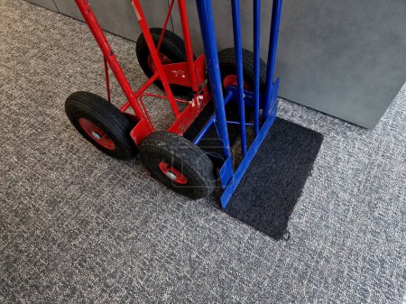 moving handcarts ready to transport plants. The two-wheeled wheelbarrow is ideal for transporting furniture and appliances indoors. red and blue on the carpet