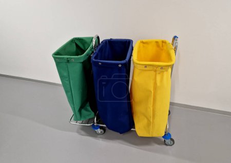 Photo for Equipping the new office with sorting carts used by the cleaning service. textile bags on chrome construction with wheels. hospital corridor - Royalty Free Image
