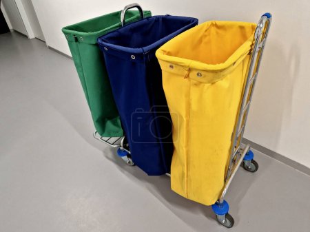 Photo for Equipping the new office with sorting carts used by the cleaning service. textile bags on chrome construction with wheels. hospital corridor - Royalty Free Image